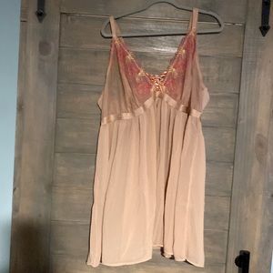 Peach colored baby doll with bright embroidered flowers